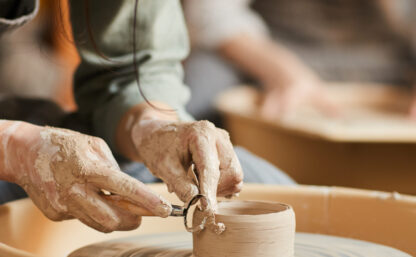 Shaping wet clay on pottery wheel