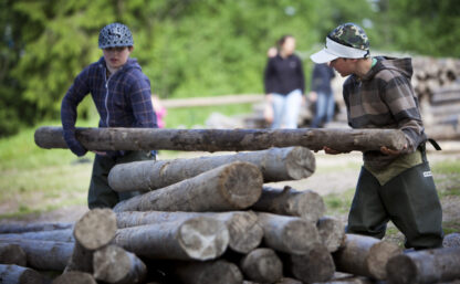 Mit Kindern reisen - zwei Jungs beim Bau eines Holzfloßes