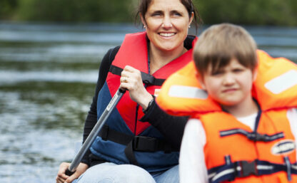 Min Kindern reisen - ein Kind mit Schwimmweste sitzt im Kanu.